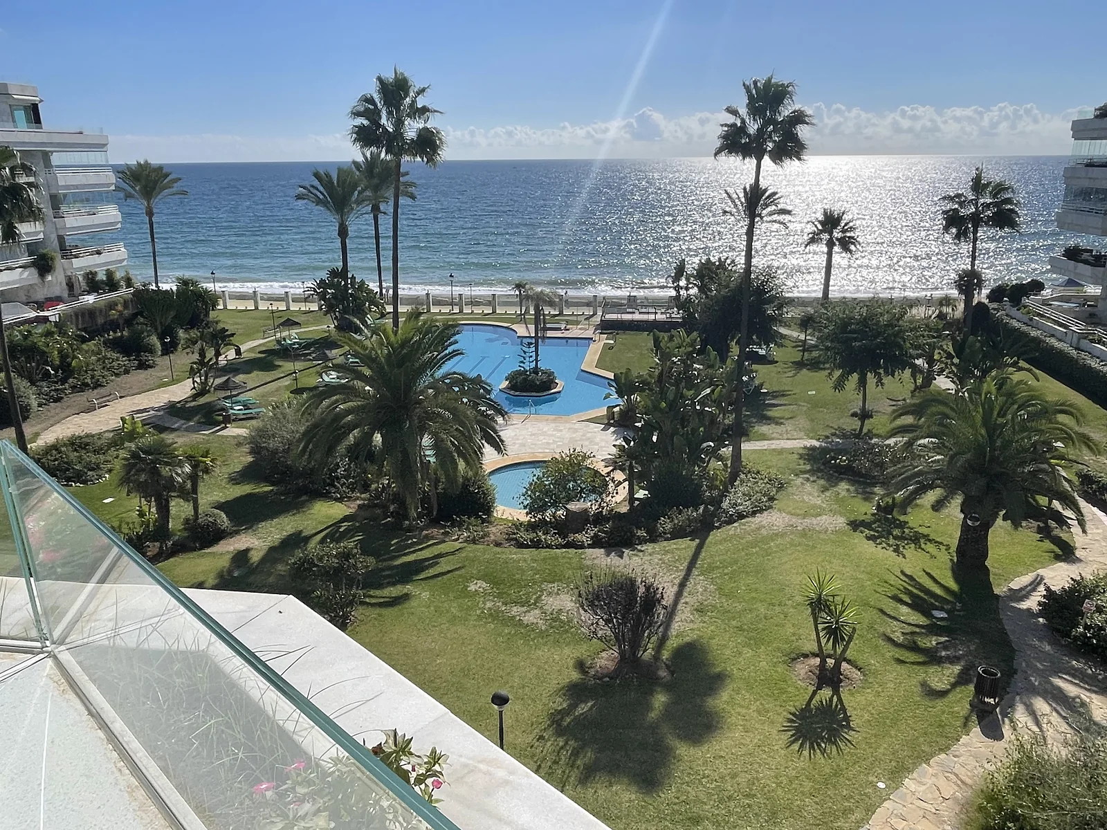 Jardines con palmeras y piscinas frente al mar