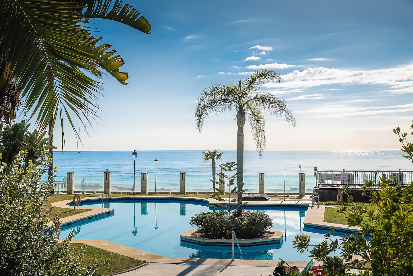 Piscina frente al mar con palmeras